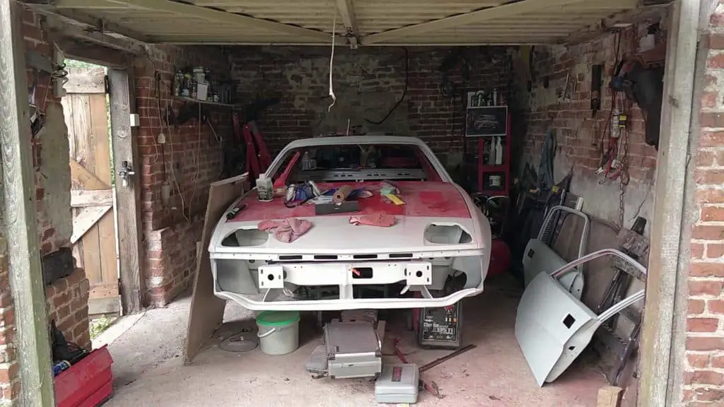 TR7 in cluttered garage.